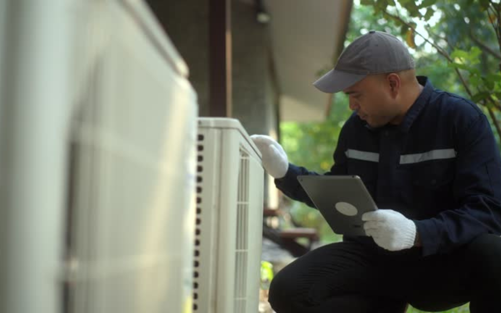 HVAC technician checking an outdoor air-conditioning unit