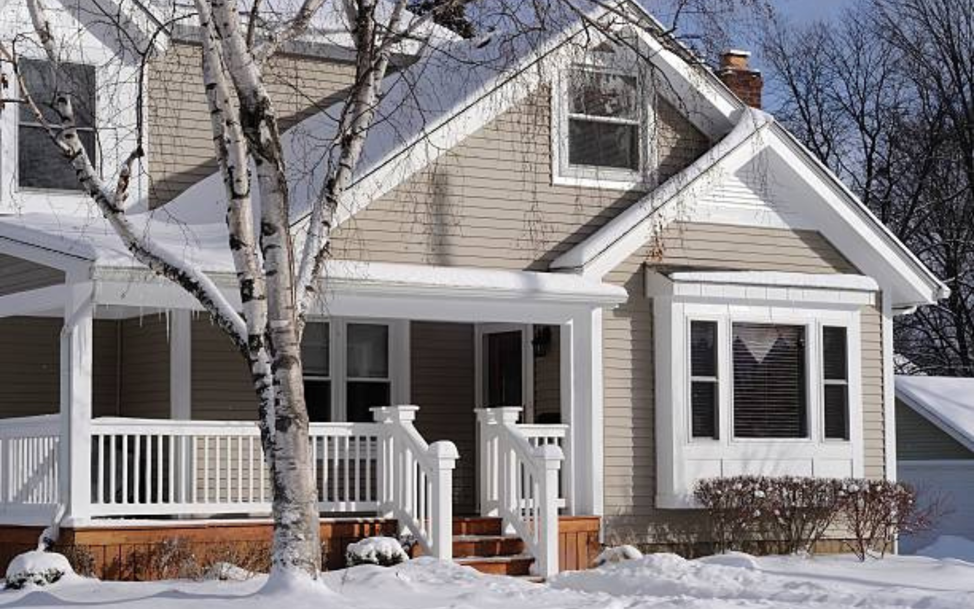 Snow-covered suburban Michigan home glowing warmly on a winter evening