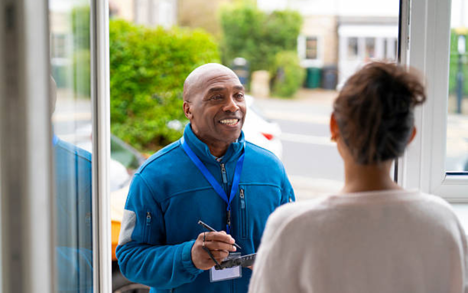 HVAC technician speaking with a homeowner at the front door